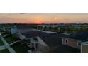 An aerial view of a residential neighborhood at sunset, with a row of houses and a colorful sky at 12820 Bent Twig Dr, Riverview, FL 33579