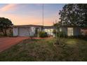 Charming single-story home featuring a well-maintained lawn and inviting curb appeal at dusk at 1629 Dartmouth Dr, Holiday, FL 34691
