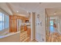 Kitchen entrance features stainless steel refrigerator, wood cabinets, and decor at 3100 Gulf Blvd # 134, Belleair Beach, FL 33786