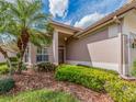 Inviting home facade with a palm tree, a tiled roof, and neat landscaping around the front entrance at 4372 Water Oak Way, Palm Harbor, FL 34685