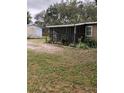 A cozy home with a screened porch, surrounded by a well-maintained yard and mature trees at 4508 E Fern St, Tampa, FL 33610