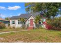 Charming bungalow-style home featuring a red front door, lush landscaping, and a curved walkway at 511 27Th N Ave, St Petersburg, FL 33704
