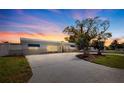 Charming single-story home featuring a well-manicured lawn and spacious driveway at sunset at 7998 Causeway N Blvd, St Petersburg, FL 33707