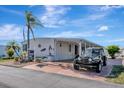 Inviting single-story home with covered parking, mature palm trees, and a beautiful driveway at 845 Jolanda Cir, Venice, FL 34285