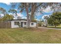 Well-maintained single story home on a green lawn with a mature tree in the yard at 1316 Barry St, Clearwater, FL 33756