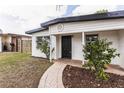 Well-kept single story home with a brick walkway, manicured bushes, and a black front door at 1316 Barry St, Clearwater, FL 33756
