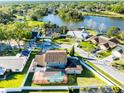 Serene aerial view of a beautiful neighborhood with a pool, surrounded by lush greenery and a tranquil lake at 1375 Corner Oaks Dr, Brandon, FL 33510