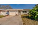 Charming single-story house featuring a front-facing garage and a welcoming front door at 1436 Temple St, Clearwater, FL 33756