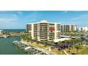 Waterfront condominium building with boat docks and covered parking surrounded by palm trees at 1651 Sand Key Estates Ct # 53, Clearwater, FL 33767