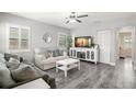 Inviting living room with modern gray floors, comfortable seating, and a bright window with stylish shutters at 1661 Grove St, Clearwater, FL 33755