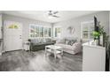 Bright living room featuring gray wood floors, lots of natural light, and cozy sofas perfect for relaxation at 1661 Grove St, Clearwater, FL 33755