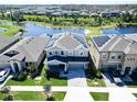 Beautiful two-story home featuring solar panels, a well-manicured lawn, and a serene lakeside view at 17802 Everlong Dr, Land O Lakes, FL 34638