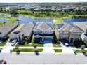 A lovely two-story home with solar panels, complemented by a lush lawn and peaceful lake backdrop at 17802 Everlong Dr, Land O Lakes, FL 34638