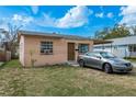 Street view of a one-story home featuring a car in the driveway, with clear blue skies above at 2501 Auburn S St, St Petersburg, FL 33712