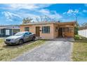 Modest single-story home with gravel driveway and a car parked in front, under a partly cloudy sky at 2501 Auburn S St, St Petersburg, FL 33712