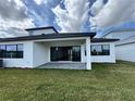 A covered back patio with a paved area and sliding glass doors, perfect for outdoor entertaining at 32347 Wetland Bird Vw, San Antonio, FL 33576