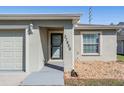 Home exterior with neutral color scheme, decorative rock landscaping, and well kept front lawn at 37850 Prairie Rose Loop, Zephyrhills, FL 33542