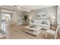 Bright living room with beach themed decor, hardwood floors, white sofa, and view into the dining area at 4711 Travertine Dr, Tampa, FL 33615