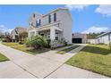 Two story home with driveway leading to detached garage and manicured landscaping at 5027 Autumn Ridge Dr, Wesley Chapel, FL 33545