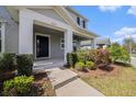 Inviting covered front porch with lush landscaping and views of the front yard at 5027 Autumn Ridge Dr, Wesley Chapel, FL 33545