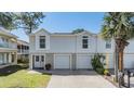 Charming townhome featuring a two-car garage, a well-manicured lawn, and a welcoming double-door entrance at 7631 Sailwinds Pass, Port Richey, FL 34668