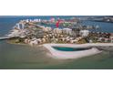 Stunning aerial view of condo complex with pool, tennis courts, beach, and bay at 830 S Gulfview Blvd # 501, Clearwater Beach, FL 33767