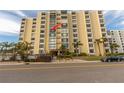 Low angle view of condo building's exterior with many windows and palm trees outside at 830 S Gulfview Blvd # 501, Clearwater Beach, FL 33767