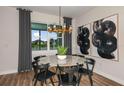 Cozy dining area featuring a marble table set, elegant lighting fixture, and serene view of the lake at 9310 Barnacle Ln, Parrish, FL 34219