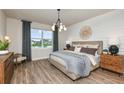 Relaxing main bedroom with a decorative accent wall, plush bedding, and a tranquil view of the lake at 9310 Barnacle Ln, Parrish, FL 34219