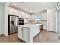 Bright, modern kitchen with stainless steel appliances, an island, white cabinets, and ample counter space at 9412 Coastline Way, Parrish, FL 34219