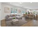 Open-concept living area featuring modern decor, a comfortable sectional, and an adjacent dining area with seating for six at 9412 Coastline Way, Parrish, FL 34219