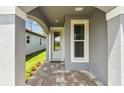 Covered entry with light-blue door, gray walls, brick pavers and window at 9466 Shorebird Ct, Parrish, FL 34219