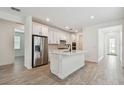 Open kitchen with stainless steel appliances, white cabinets, and a central island at 9470 Shorebird Ct, Parrish, FL 34219