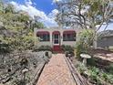 Bungalow with red awnings and a charming brick path leading to the front door at 1103 Charles St, Clearwater, FL 33755