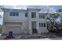 New construction home boasts a modern exterior, two-car garage, and meticulously landscaped front yard, adding curb appeal at 1105 W Peninsular St, Tampa, FL 33603