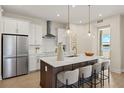 Bright kitchen with white cabinets, stainless appliances, center island, and pendant lighting at 12785 Jade Empress Loop # 101, Venice, FL 34293