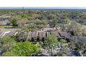 Aerial view of condo building with parking in the rear, and mature trees on the property at 13385 Arbor Pointe Cir # 203, Tampa, FL 33617