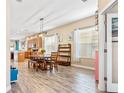 Open dining room with a wood table, wood-look floors, and access to the kitchen at 16313 Dinsdale Dr, Spring Hill, FL 34610