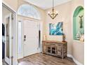 Inviting foyer with stylish chandelier, decorative wall niche, and a charming wood-look console table at 16313 Dinsdale Dr, Spring Hill, FL 34610