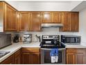 Well-lit kitchen with stainless steel appliances, oak cabinetry, and ample countertop space at 2009 Hammock Pine Blvd # 2009, Clearwater, FL 33761