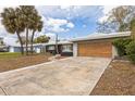 Exterior of a charming single story home with a two-car garage and a wide driveway at 2080 Attache Ct, Clearwater, FL 33764