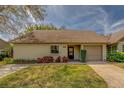 Inviting single-story home featuring a one car garage, manicured lawn and lush landscaping at 2847 Rampart Cir, Clearwater, FL 33761