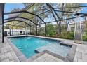 A screened-in pool area featuring a swimming pool, jacuzzi, fountains, and a patio space at 31123 Stone Arch Ave, Wesley Chapel, FL 33545
