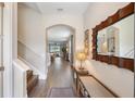 Inviting entryway with hardwood floors, decorative mirror, bench and stairway to the upper level at 3991 Mellon Dr, Odessa, FL 33556