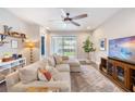 Comfortable living room with neutral sectional sofa, large windows, ceiling fan and access to the backyard at 3991 Mellon Dr, Odessa, FL 33556