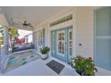 Inviting front porch with a swing, decorative front door, and beachy accents at 413 Islebay Dr, Apollo Beach, FL 33572