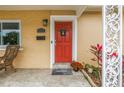 Close-up of a vibrant red front door with decorative welcome mat and plants at 4322 22Nd N Ave, St Petersburg, FL 33713