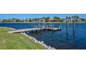 Waterfront view of wooden dock and boat lift on a sunny day with calm, blue water at 5321 Fishersound Ln, Apollo Beach, FL 33572