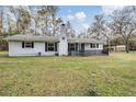 Charming single-story home with a white brick facade, black shutters and a cozy front porch at 5419 Cyril Dr, Dade City, FL 33523