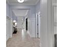 Bright hallway with pristine white wainscoting and neutral ceramic tile flooring at 5611 S Russell St, Tampa, FL 33611